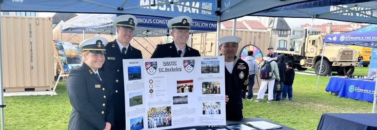 Four Midshipmen in dress uniform tabling and the Colorado Meet Event