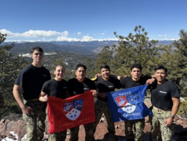 Group of six midshipmen proudly holding NROTC UC Berkeley flags in the Colorado outdoors